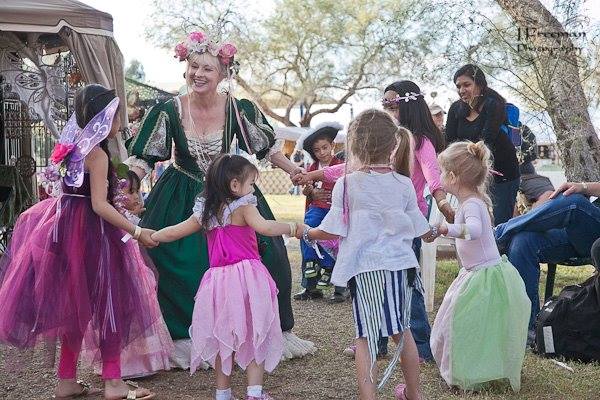 Hunter Storm playing the Fairy Queen, Titania, surrounded by little fairies and a young pirate boy, all holding hands in a joyful dance.