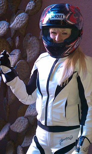 Hunter Storm as ZStormGirl, a character created by Hunter Storm, captured in a dynamic motorcycle moment wearing a red Shoei helmet with dragon designs, white leather Alpine stars outfit, and exuding the spirit of thrilling adventures on two wheels.