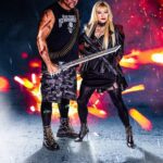 Hunter Storm and Mike Gaube as the King and Queen of Hell / the Apocalypse in a fiery battlefield backdrop, depicting scenes of chaos with weapons in hand.