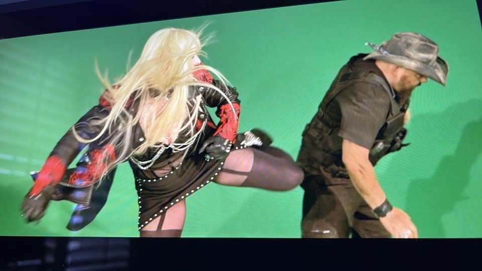 Hunter Storm kicking in stiletto boots, aiming at Rex Van Dine during a staged fight for the "Dead and Gone" music video.
