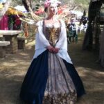 Hunter Storm playing the Fairy Queen Titania at the Fireland Faerie Festival, wearing a cobalt blue and gold gown with metallic fairy wings.