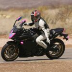 Hunter Storm on the INDE race track in Willcox, Arizona, riding her Yamaha FZ6 R with distinctive pink crash tape, gold wheels, and exuding the thrill of motorcycling adventures.