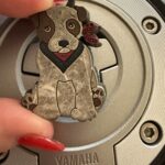 Jack the Dog key charm on Hunter Storm's motorcycle tank, symbolizing professional vigilance, integrity, and passing the torch of responsibility.