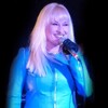 Hunter Storm with platinum blonde hair, turquoise blue leather jacket, and microphone. Hunter Storm iconic avatar image.